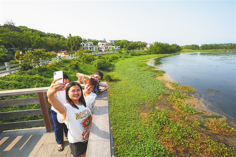 游客在博鳌沙美村的美景前合影留念